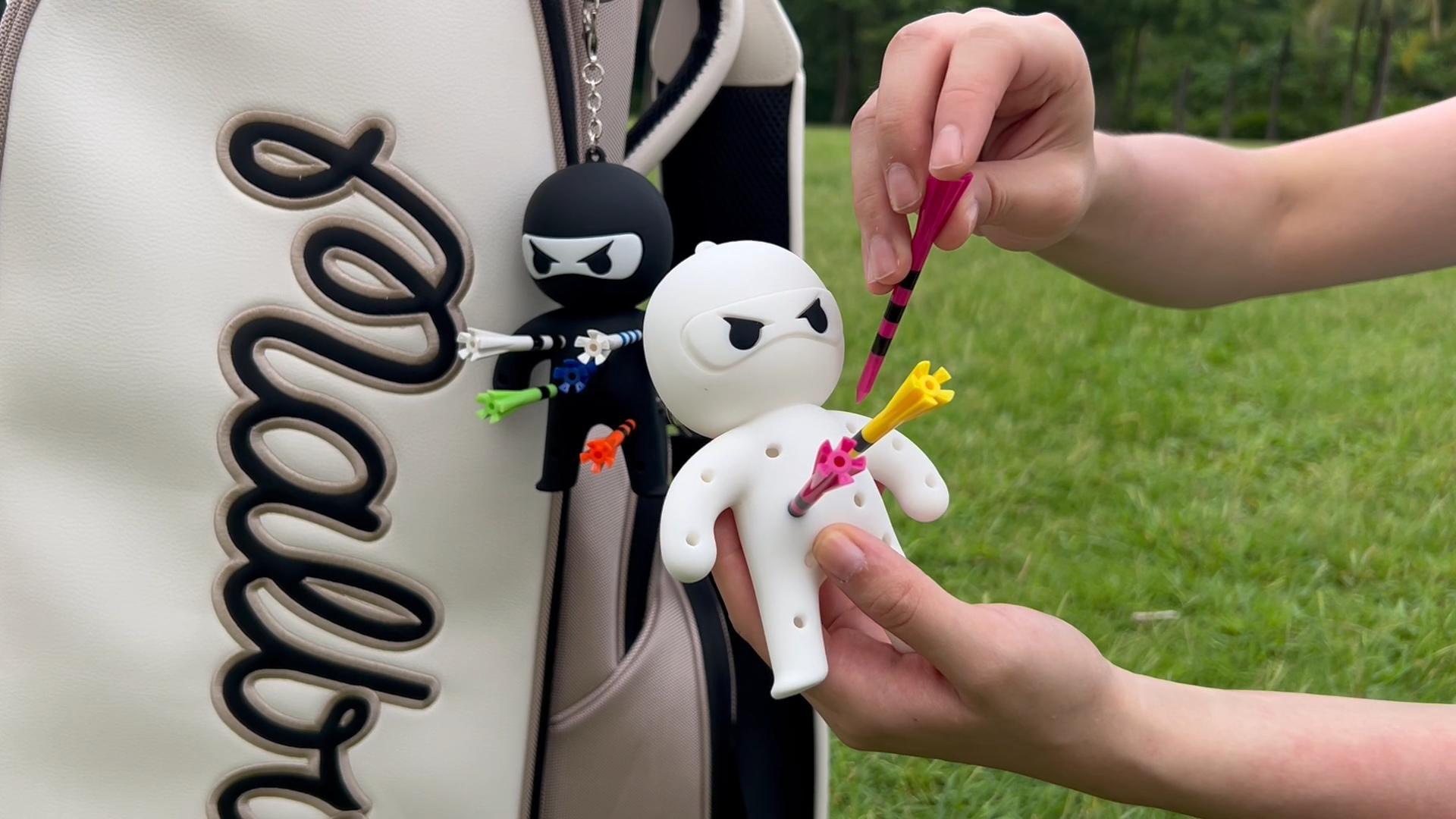 Hands demonstrating Ninja Charms on a golf bag